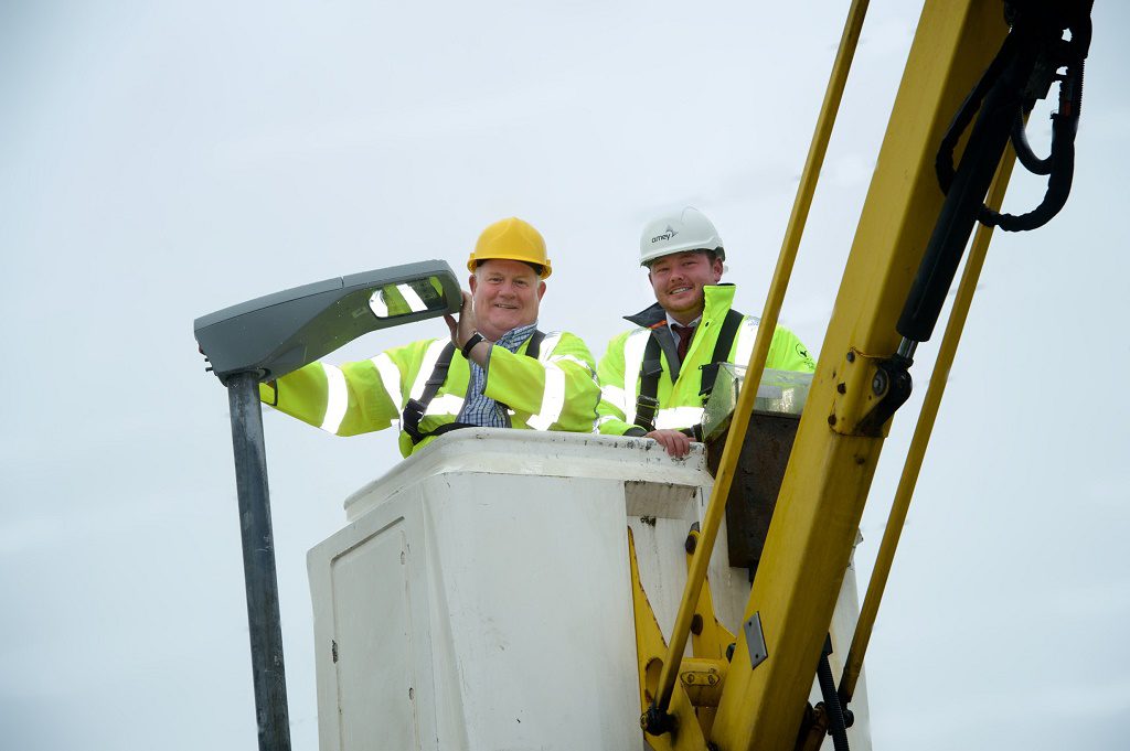 Councillor Eddie Devine (left) fitting one of the new LED lamps