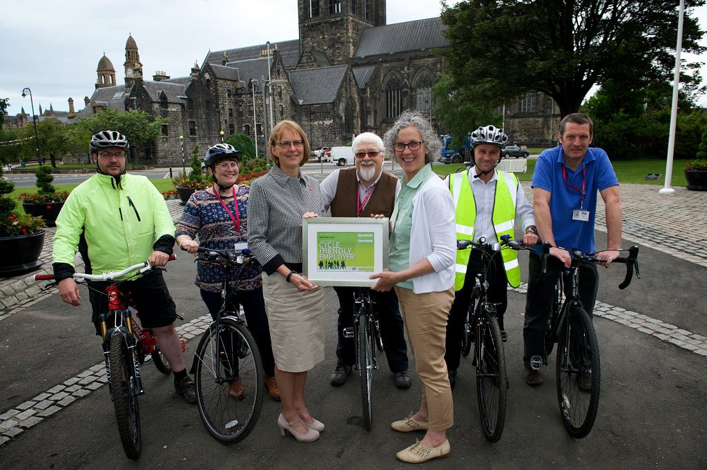 orothy Hawthorn (L) receives the Cycle Friendly Employer award from Laura Carswell (R) outside Renfrewshire House in Paisley. The photo also shows members of Renfrewshire Council staff