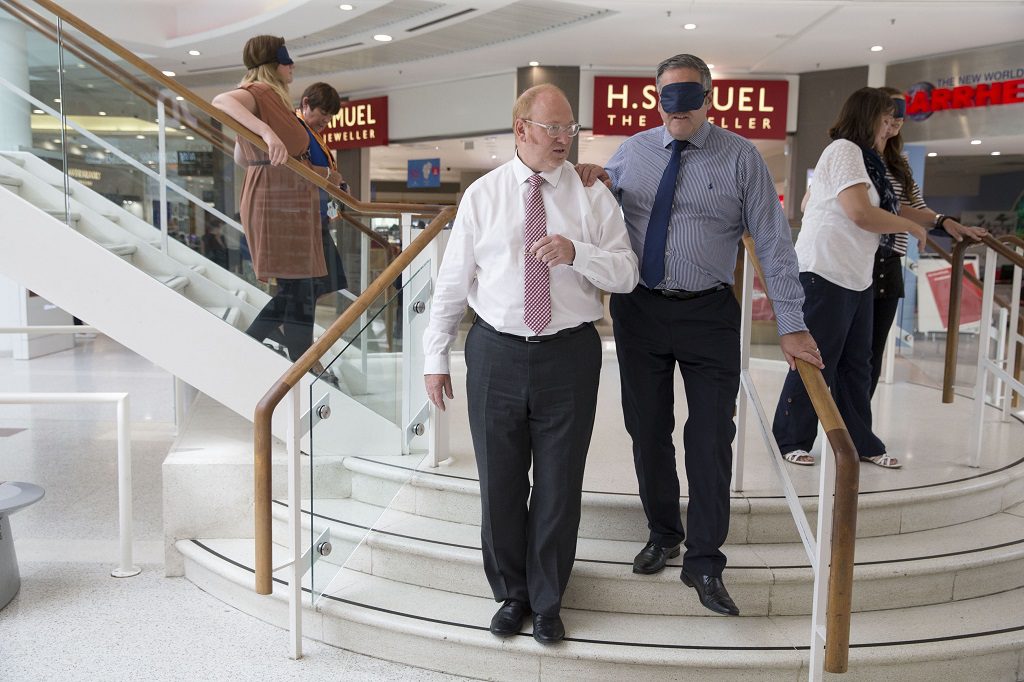 Blindfold intu Braehead boss, Peter Beagley is led through the mall by guest services manager, Bruce Harley during the Visibility training session.