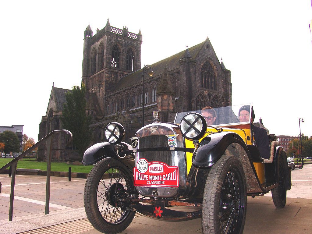 Driver Andrew Goodfellow and co-driver Derek Coghill in their 1930 Austin Seven Ulster 2-seater sports with Paisley Abbey in background
