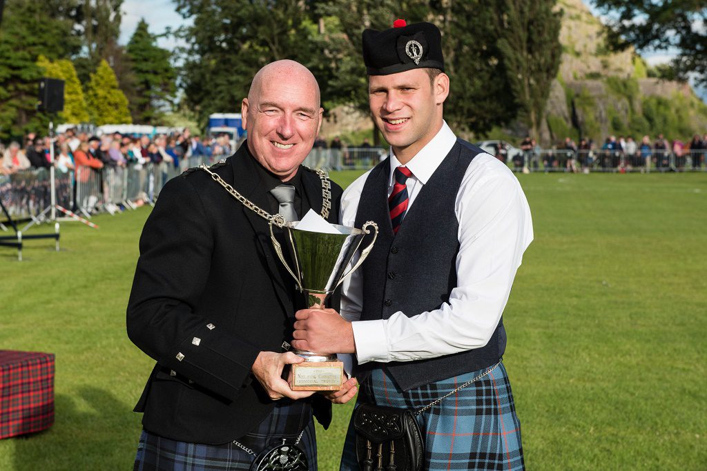 Shows Pipe Major Keith Bowes Jr picking up the Grade 2 third place trophy. 